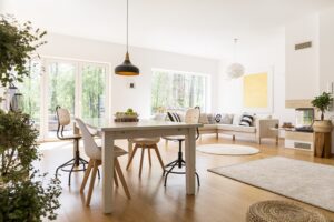 Plants in spacious white living room connected with dining hall