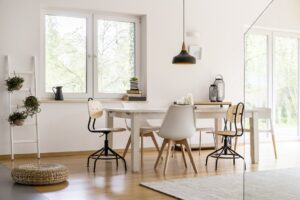 White modern dining hall with big table and designer chairs